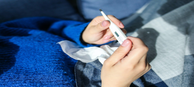 Hand mit Fieberthermometer