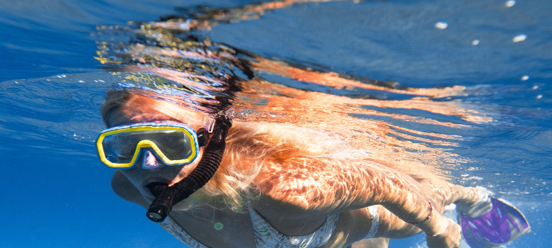 Frau mit Taucherbrille im Pool, um das Loch im Whirlpool zu finden