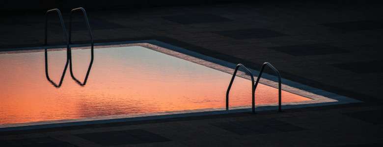 Pool bei Sonnenuntergang: Wann und warum den Pool abdecken?