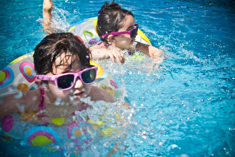 Kinder mit Spielzeug im Pool