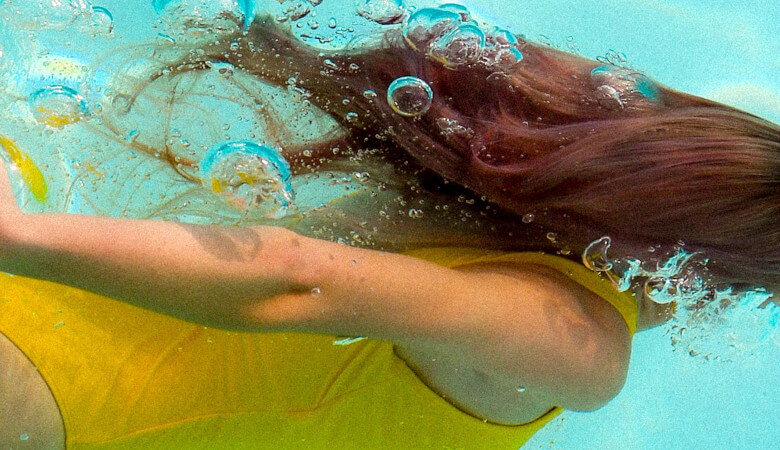 Frau schwimmt – Was kostet ein kleiner Pool mit Gegenstromanlage=