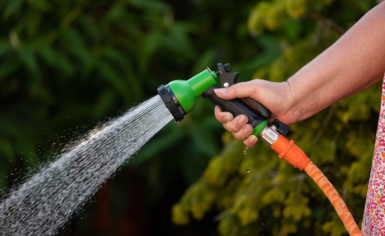 Hand mit Gartenschlauch: Wasser für den Whirlpool?