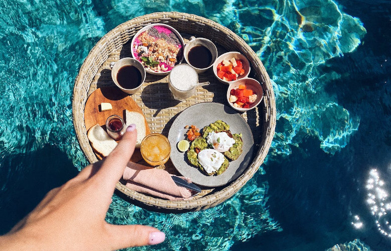 Tablett mit Essen und Getränken auf dem Wasser schwimmend